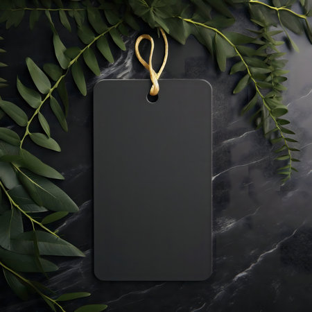Blank black tag on dark marble with green leavesの写真素材