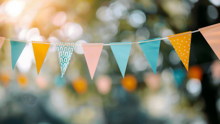 A string of colorful bunting hangs in a sunny garden, creating a festive atmosphere.の写真素材