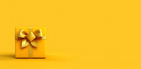 A single yellow gift box with a golden bow sits on a yellow background. Minimalist and festive.の写真素材