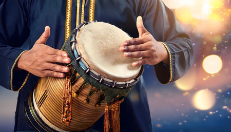 Close-up of a person playing a traditional drum. The image evokes a sense of cultural heritage and musical tradition.の写真素材