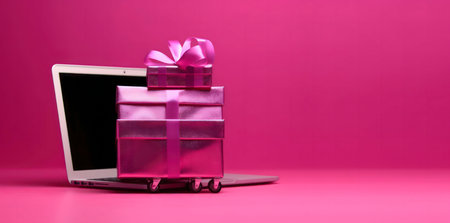 Pink gifts on a laptop, online shopping conceptの写真素材