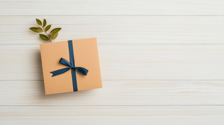 Gift box with blue bow on white wooden background with copy space