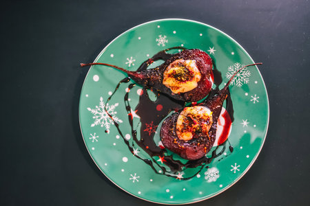 Pears with chocolate and strawberry sauce on christmas table, stock photo