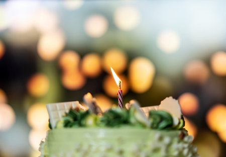 Birthday cake with candles on bokeh background, shallow depth of fieldの写真素材