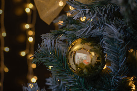 Close up of decorated christmas tree with golden baubles.