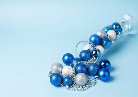 Christmas decoration on blue background with copy space. Blue and silver christmas balls and beads
