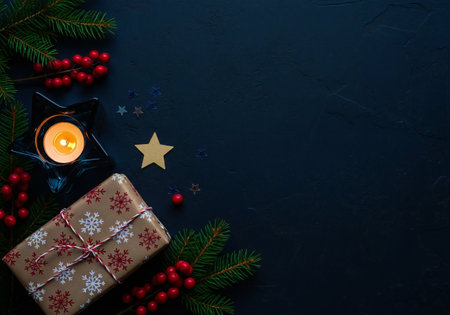 Christmas background with fir branches, candles and gift boxes on black backgroundの写真素材