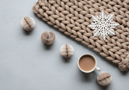 Cup of coffee and knitted scarf on gray background, top viewの写真素材
