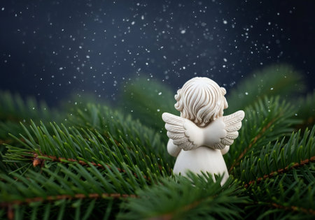 Christmas angel on green fir tree branch with falling snow, copy spaceの写真素材
