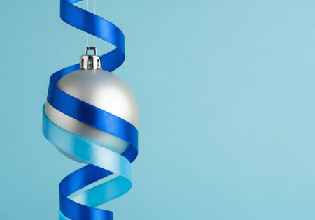 Christmas decoration with blue ribbon on blue background. Copy space for text.の写真素材