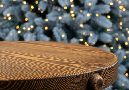 Wooden table in front of christmas tree with bokeh lightsの写真素材
