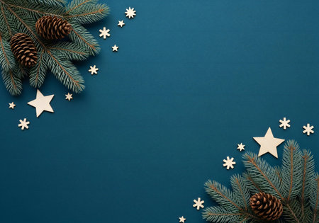 Christmas background with fir branches, cones and snowflakes on a blue backgroundの写真素材