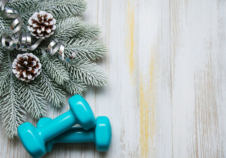 Blue dumbbells, fir tree branch and Christmas decoration on white wooden backgroundの写真素材