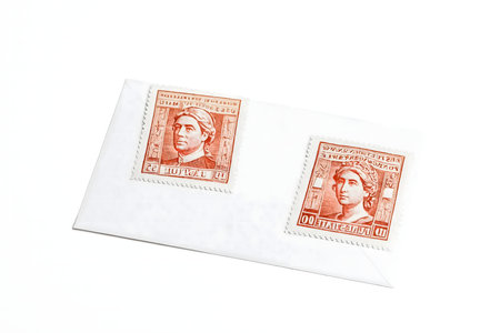 Two vintage red postage stamps on a white paper sheet