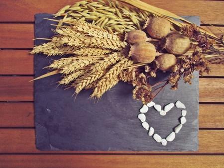 dried flowers on a slate board with a heartの写真素材