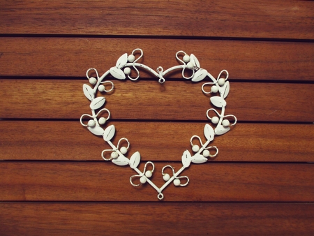 white metal heart on a wooden backgroundの写真素材