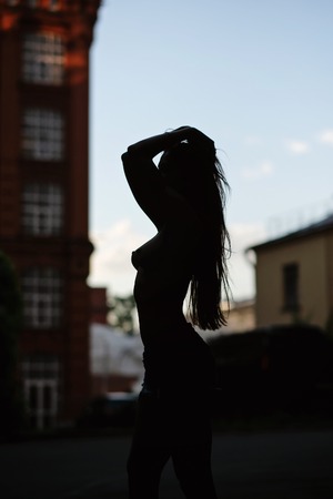 Silhouette of half nakd woman in the city. Fashion art photo.の写真素材