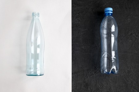 Plastic free concept. Glass and plastic bottle on white and black background. Flat layの写真素材