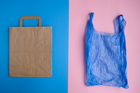 Plastic free concept. Paper bag and plastic bag on blue and pink background. Flat layの写真素材