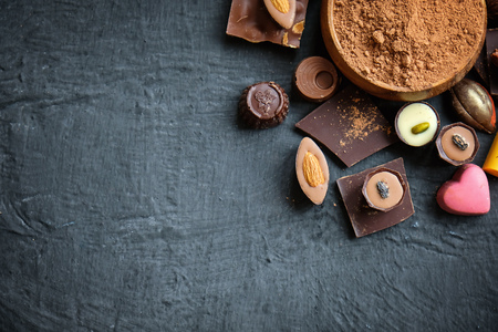 Assorted chocolate and cocoa powder on black backgroundの写真素材