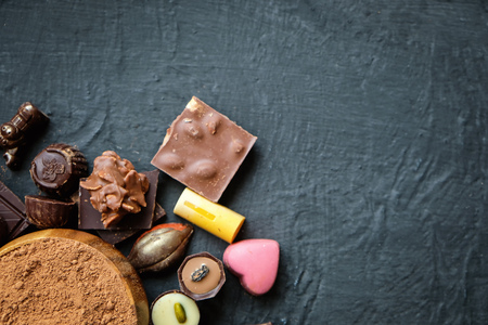 Assorted chocolate and cocoa powder on black backgroundの写真素材