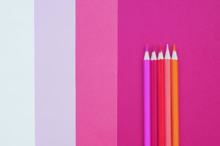 Abstract geometric paper background with color pencils. Pink and coral trendy colors. School and education concept.の写真素材