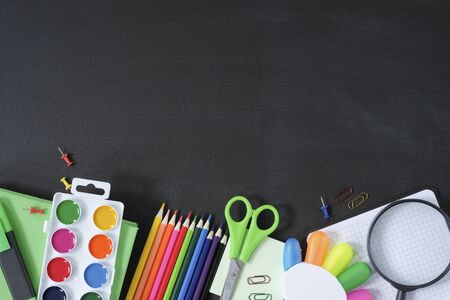 School supplies on black board background. Back to school concept. View from above