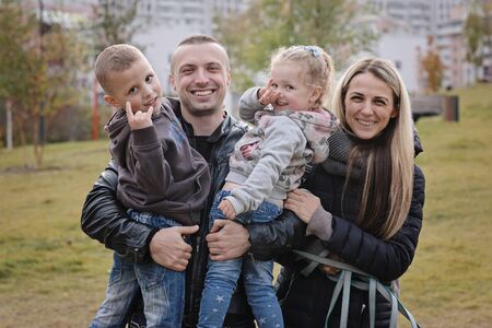 Happy family with little kids in the park, autumn outdoors