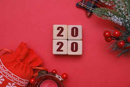 Christmas and new year 2020 concept, wooden cubes and decorations on red background