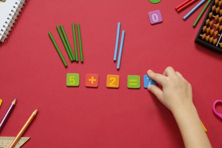 Math concept: colorful pens and pencils, number, calculating sticks in red backgroundの写真素材