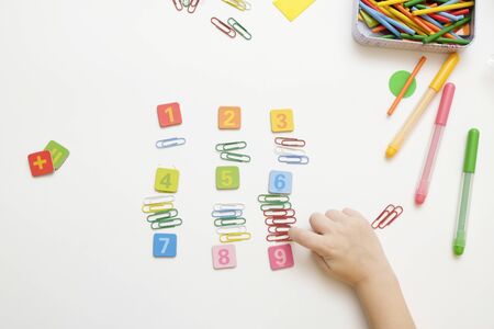 Little boy child preparing for elementary school doing simple Mathematics exercises. View from above
