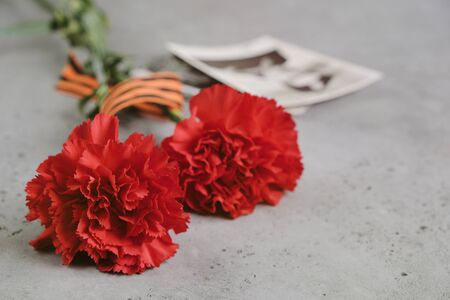 9 May holiday. Victory Day background - George ribbon, red flowers carnation.の写真素材