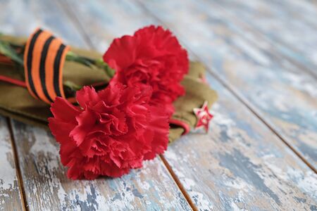 9 May holiday. Victory Day background - George ribbon, red flowers carnation.の写真素材