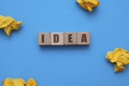 IDEA concept - flat lay composition with wooden cubes at office workspace on blue backgroundの写真素材