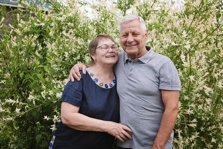 Beautiful senior couple - mature man and woman at their house, outdoors