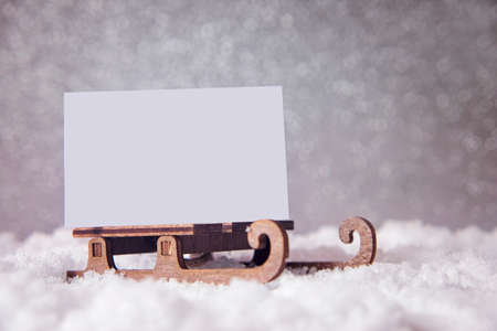 Christmas card on a sled on snow. Glitter festive background