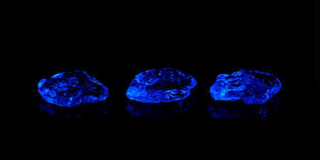 three blue ice cubes on black backgroundの写真素材