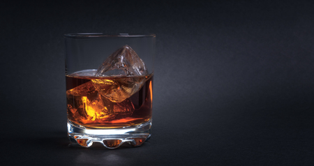 Whiskey with ice cubes on dark backgroundの写真素材