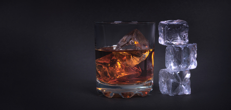 Whiskey with ice cubes on dark backgroundの写真素材