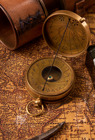 Old vintage retro compass on ancient world map. Vintage still life. Travel geography navigation concept background.の写真素材