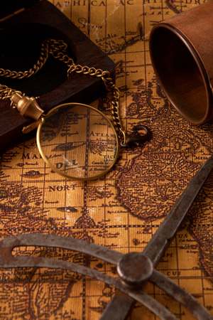 Old vintage retro compass on ancient world map. Vintage still life. Travel geography navigation concept background.の写真素材