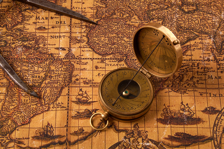 Old vintage retro compass on ancient world map. Vintage still life. Travel geography navigation concept background.の写真素材