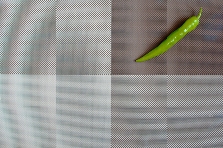 Green pepper on a rectangular background of gray, brown and whiteの写真素材