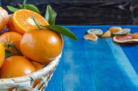 Citrus tangerines in a basket on a blue backgroundの写真素材