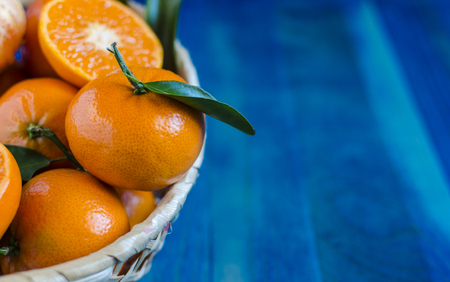 Citrus tangerines in a basket on a blue backgroundの写真素材