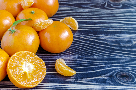 Tangerines with leaves on a dark wooden backgroundの写真素材