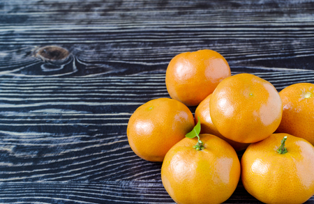 Tangerines with leaves on a dark wooden backgroundの写真素材