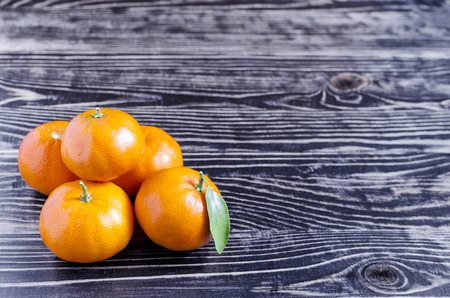 Tangerines with leaves on a dark wooden backgroundの写真素材