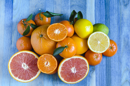 Citrus tangerines oranges lemons lime close-up on blue backgroundの写真素材