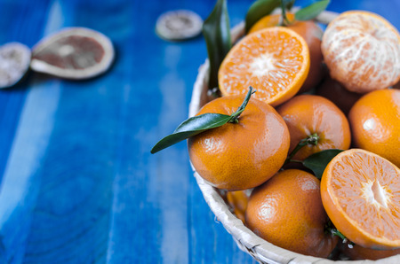 Citrus tangerines in a basket on a blue backgroundの写真素材